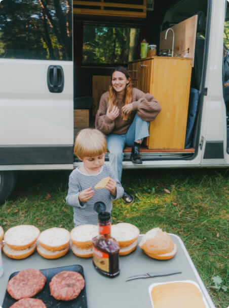 Mother and son cooking outside of an RV