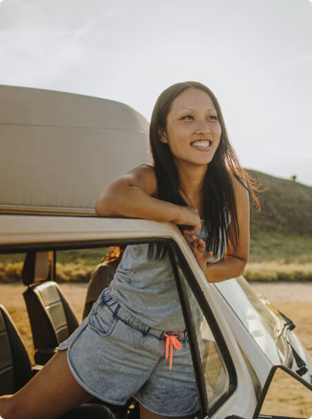 Woman smiling from the door of an RV